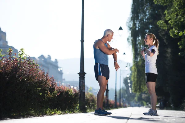 Joggingpaar plant Laufstrecke und legt Musik auf — Stockfoto