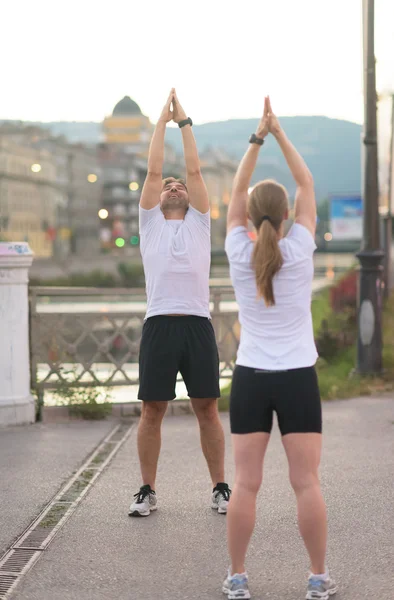 Pareja calentando antes de trotar —  Fotos de Stock