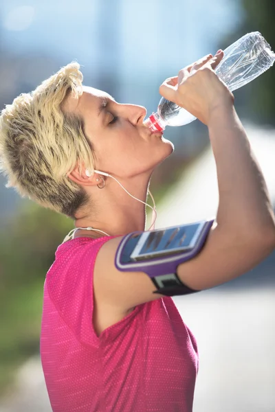 Femme boire de l'eau après le jogging — Photo