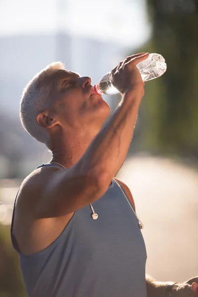 Senior jogging hombre bebiendo agua dulce de botella — Foto de Stock