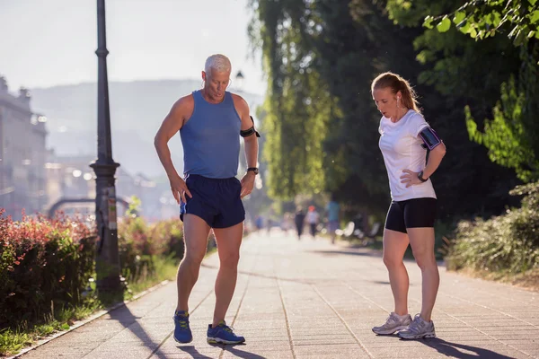 Jogging couple planning running route  and setting music — Stock Photo, Image