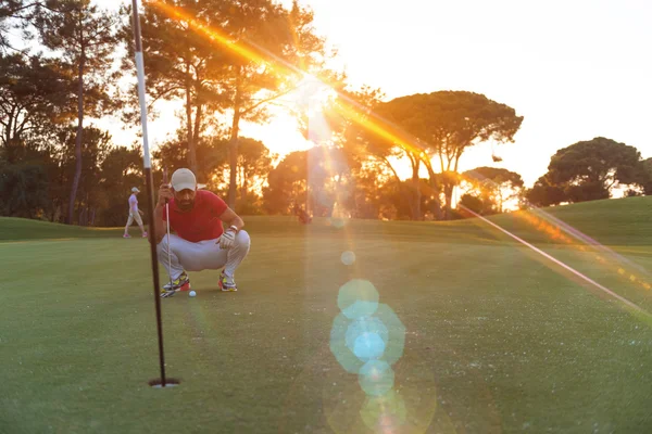 Jogador de golfe apontando tiro perfeito no pôr do sol bonito — Fotografia de Stock