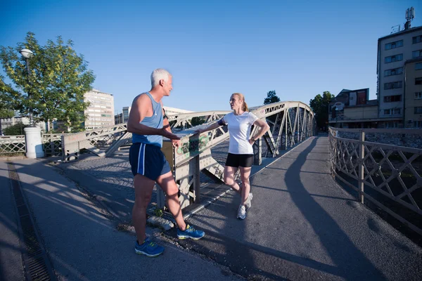 Jogging, pár plánování spuštěna směrování a nastavení hudby — Stock fotografie