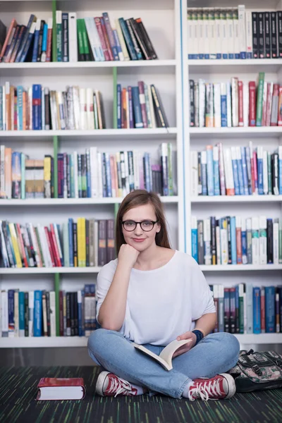 Famale student leesboek in bibliotheek — Stockfoto