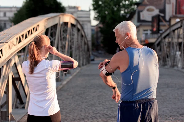 Jogging couple planification course itinéraire et réglage de la musique — Photo