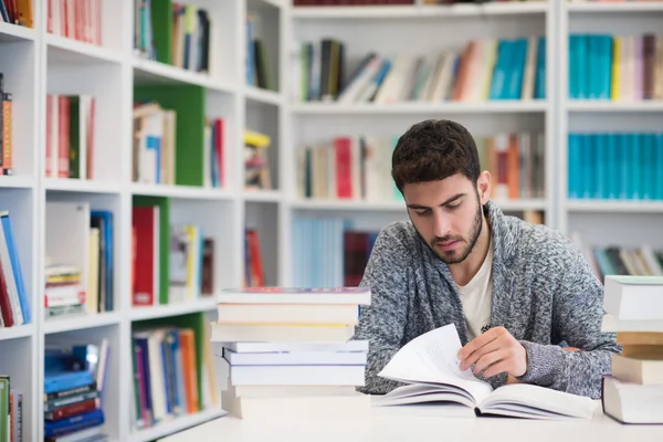 Portrait d'un élève en lisant un livre à la bibliothèque de l'école — Photo