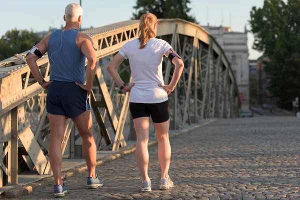 Joggingpaar plant Laufstrecke und legt Musik auf — Stockfoto