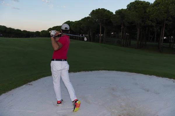 Golfista golpeando un tiro bunker de arena en la puesta del sol —  Fotos de Stock