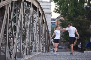 couple warming up and stretching before jogging clipart