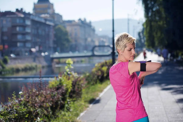 Jogging kvinna inställningen telefon innan jogging — Stockfoto