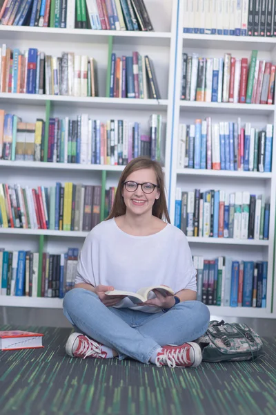 Famale Studentin liest Buch in Bibliothek — Stockfoto
