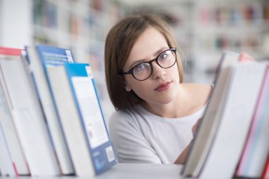 kitaplıkta okumak için kitap seçme famale öğrenci portresi