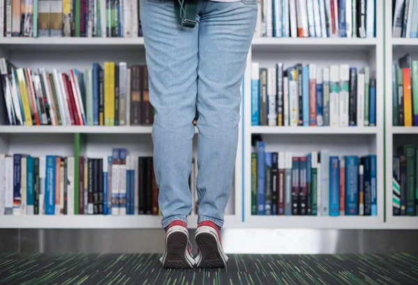 Famale student selecteren boek om te lezen in de bibliotheek — Stockfoto