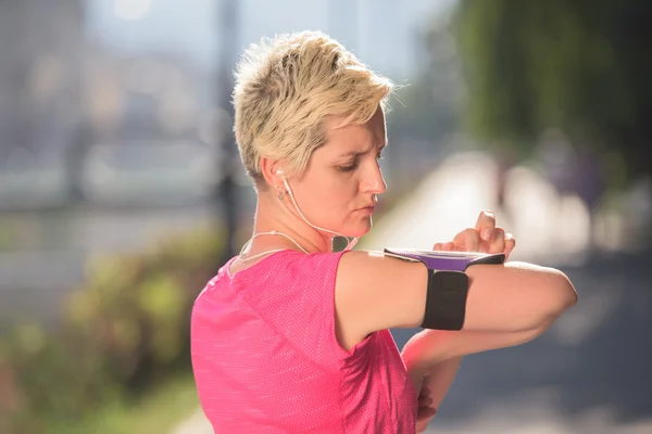 Jogging donna impostazione telefono prima di fare jogging — Foto Stock