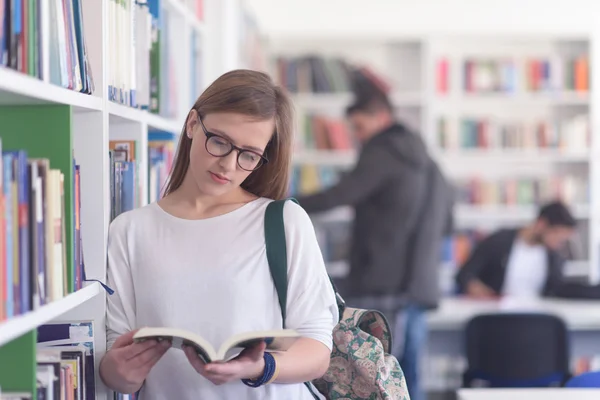 Portret van famale student leesboek in bibliotheek — Stockfoto