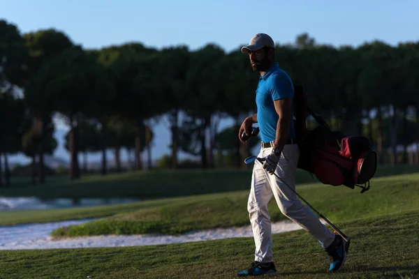 Golfista caminando y llevando bolsa de golf al atardecer hermoso —  Fotos de Stock