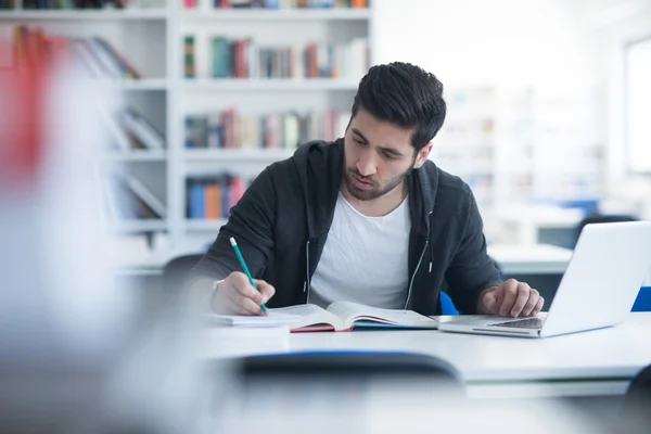 Estudante na biblioteca da escola usando laptop para pesquisa — Fotografia de Stock