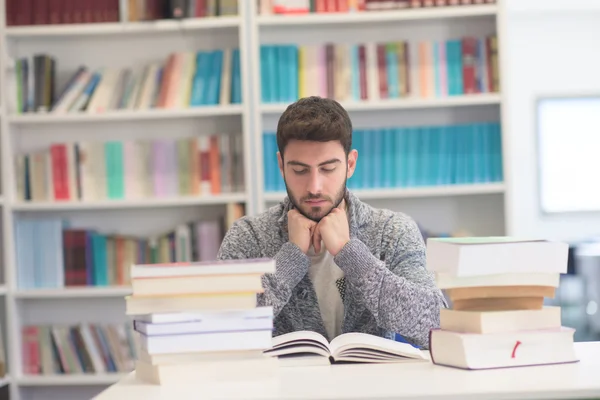 Portrait d'un élève en lisant un livre à la bibliothèque de l'école — Photo