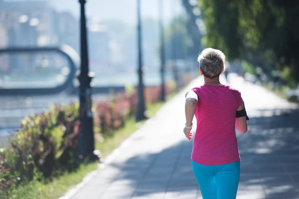 Sportliche Frau läuft auf Gehweg — Stockfoto