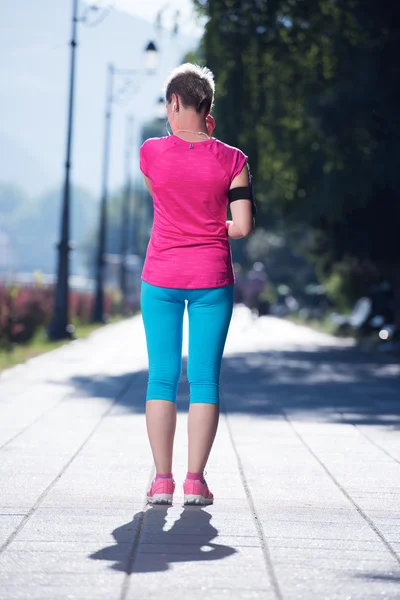 Спортивная женщина бегает по тротуару — стоковое фото