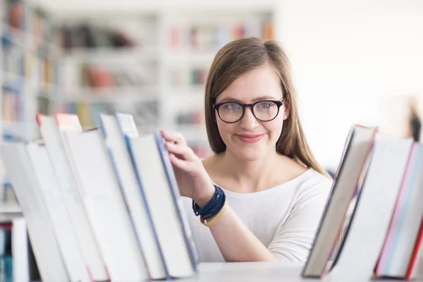 Ritratto dello studente famale che seleziona il libro da leggere in biblioteca — Foto Stock