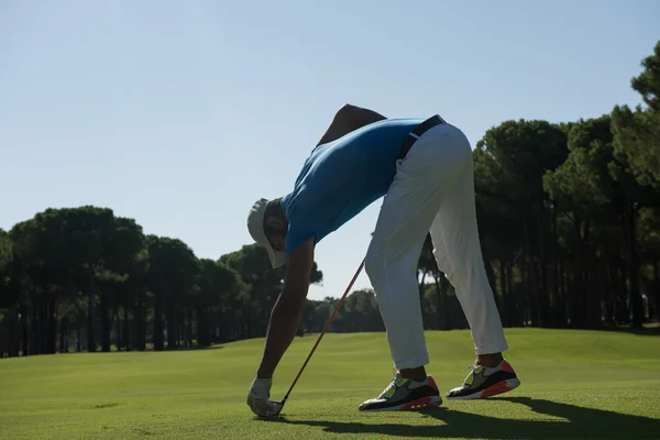 Игрок в гольф ставит мяч на тай — стоковое фото