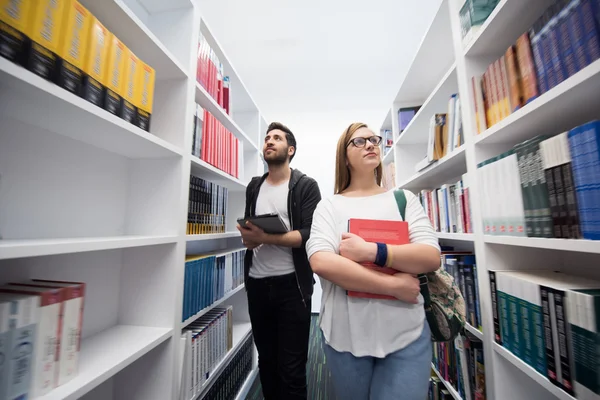 Skupina studentů ve školní knihovně — Stock fotografie