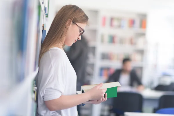 Retrato del estudiante de famale leyendo un libro en la biblioteca — Foto de Stock