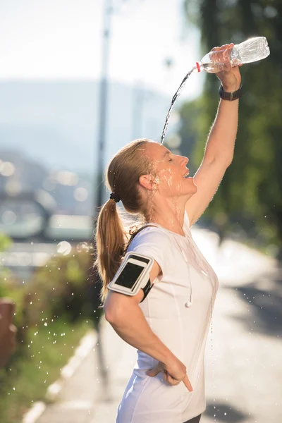 Женщина пьет воду после пробежки — стоковое фото