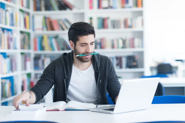 Estudante na biblioteca da escola usando laptop para pesquisa — Fotografia de Stock