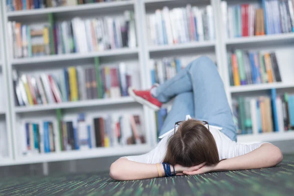 Studente donna studiare in biblioteca, utilizzando tablet e alla ricerca di — Foto Stock