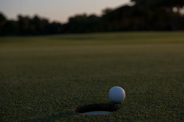 М'яч для гольфу на краю отвору — стокове фото