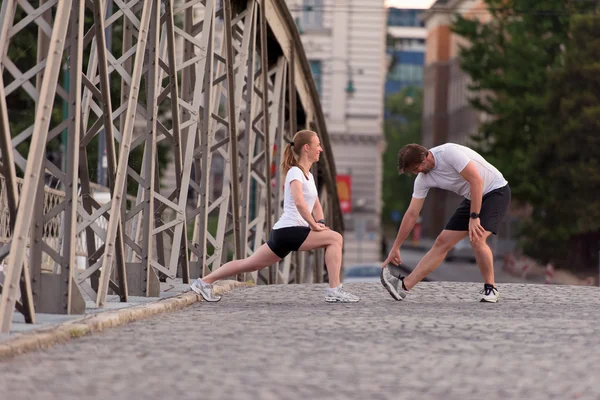 Paar wärmt sich auf und dehnt sich vor dem Joggen — Stockfoto