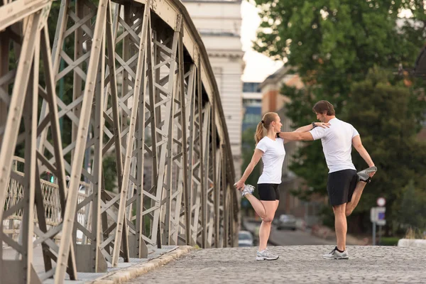 Para rozgrzewa się i rozciąga przed joggingiem — Zdjęcie stockowe