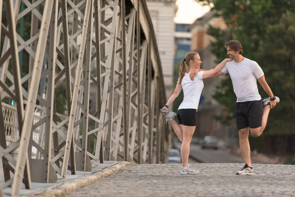 Paar wärmt sich auf und dehnt sich vor dem Joggen — Stockfoto