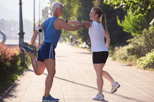 Para rozgrzewa się i rozciąga przed joggingiem — Zdjęcie stockowe