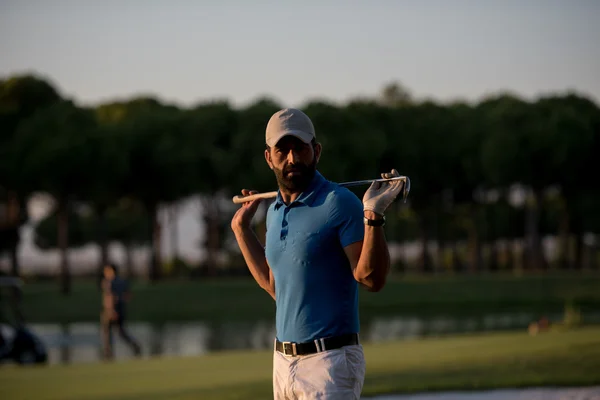 Portret van de golfer op de golfbaan op zonsondergang — Stockfoto