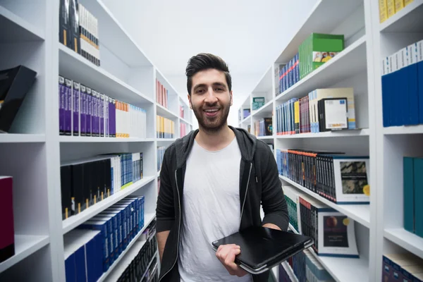 Student met tablet in bibliotheek — Stockfoto