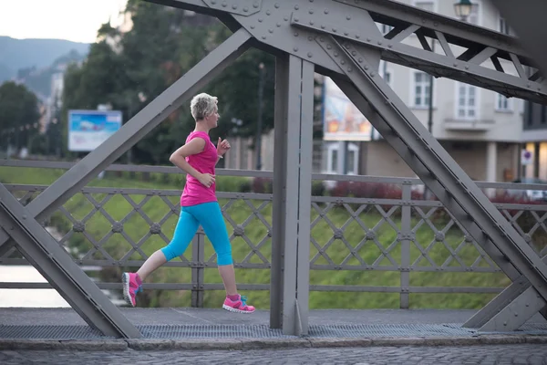 Sportliche Frau läuft auf Gehweg — Stockfoto