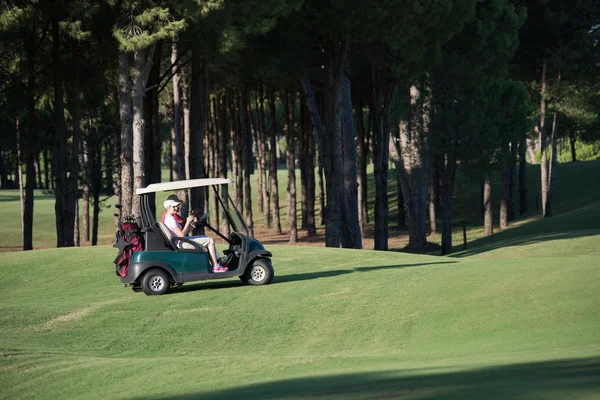 Pareja en buggy en campo de golf —  Fotos de Stock