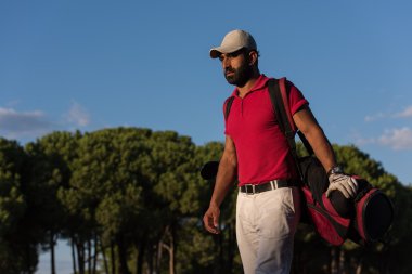 yürüyüş ve golf çantası taşıyan golfçü