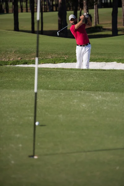 Golfista uderzanie piasku bunkra — Zdjęcie stockowe