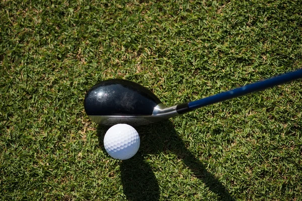 Ovansida av golf club och bollen i gräs — Stockfoto