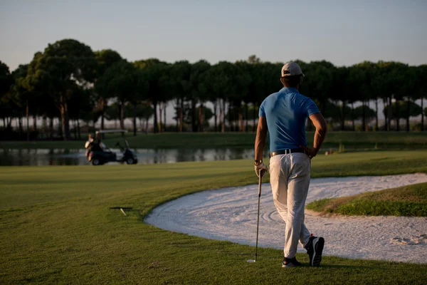 Golfista da dietro al corso cercando di bucare in distanza — Foto Stock