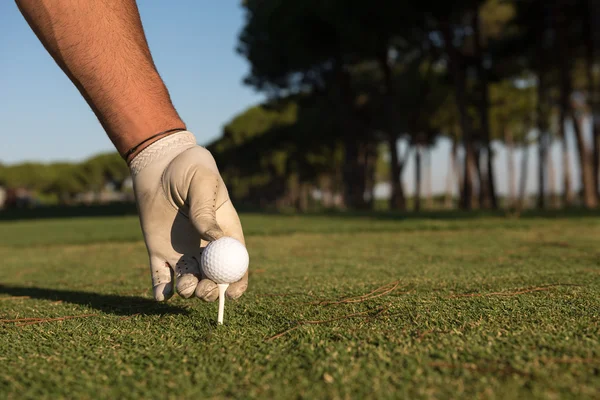 Közelkép a golf játékosok kezét helyezve a labdát a póló — Stock Fotó