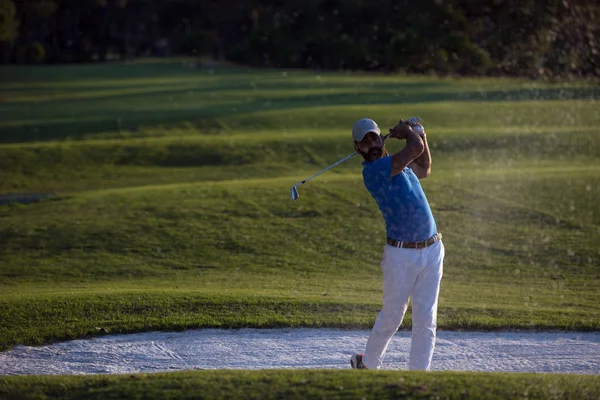 Golfista batendo um bunker de areia tiro no pôr do sol — Fotografia de Stock