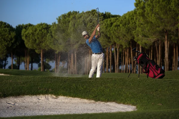 Golfer schlägt bei Sonnenuntergang in Sandbunker ein — Stockfoto