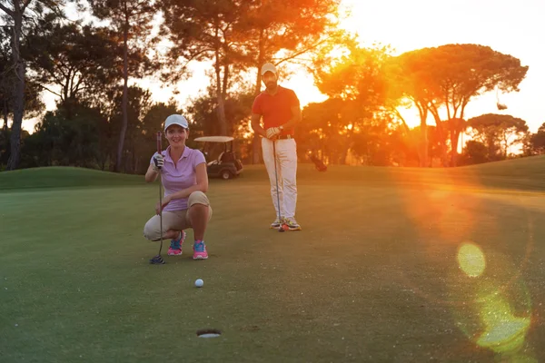 Para na pole golfowe o zachodzie słońca — Zdjęcie stockowe