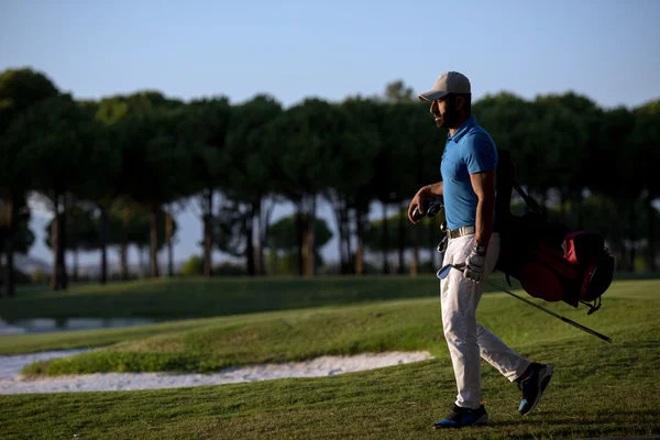 Golfer geht und trägt Golftasche bei schönem Sonnenuntergang — Stockfoto