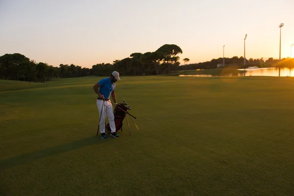 Golfeur marchant et portant sac de golf au beau coucher de soleil — Photo